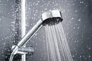 Fresh Shower Behind Wet Glass Window With Water Drops Splashing.